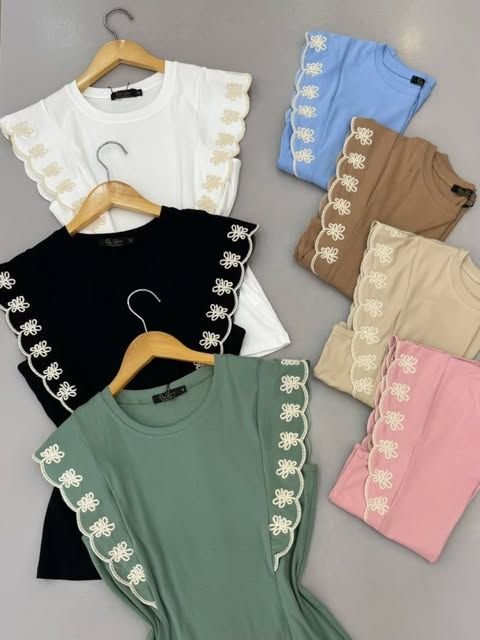 Blusas com aplicação de renda nas mangas, em várias cores, penduradas em cabides